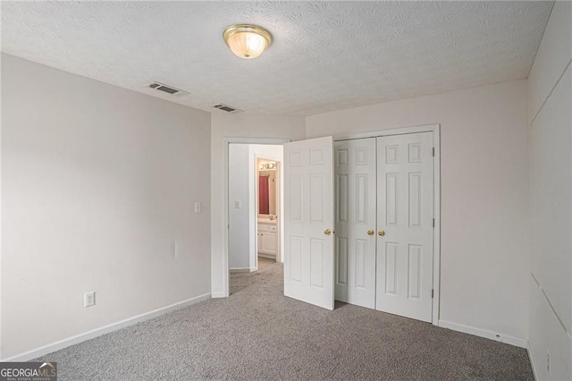 190 The Falls Blvd, Covington, GA 30016 - unfurnished bedroom with carpet floors, a textured ceiling, baseboards, and a closet
