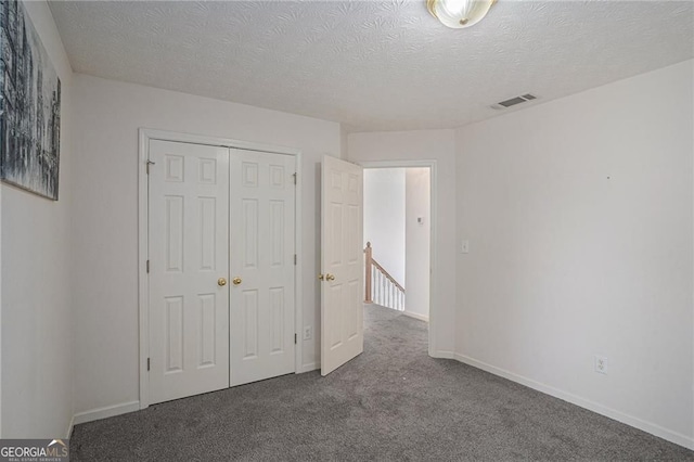 190 The Falls Blvd, Covington, GA 30016 - unfurnished bedroom featuring carpet flooring, a closet, a textured ceiling, and baseboards