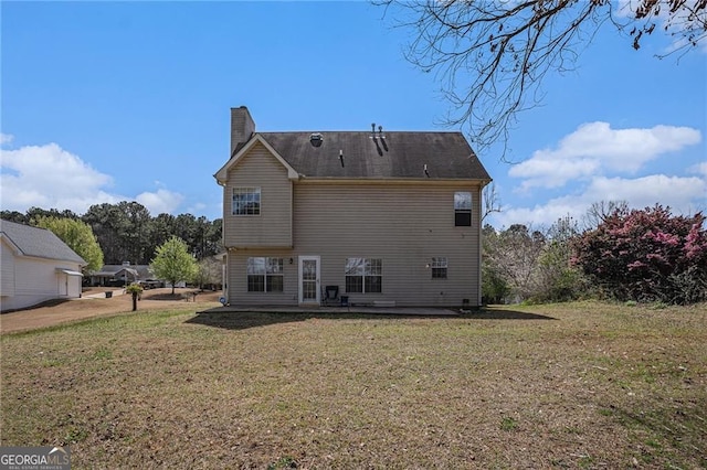 190 The Falls Blvd, Covington, GA 30016 - back of property with a chimney, a lawn, and a patio area