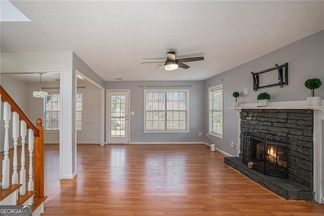 190 The Falls Blvd, Covington, GA 30016 - unfurnished living room featuring wood finished floors, ceiling fan, a fireplace, and baseboards