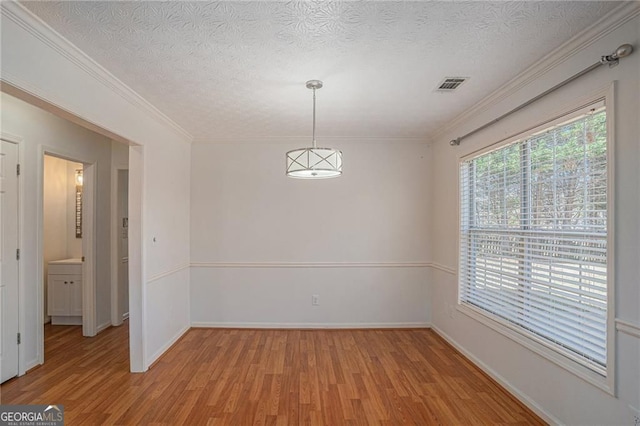 190 The Falls Blvd, Covington, GA 30016 - empty room featuring light wood-style flooring, baseboards, a textured ceiling, and crown molding
