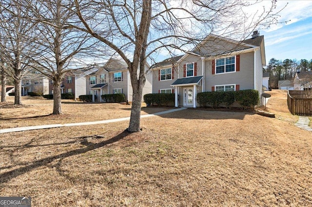 view of front of property with a chimney, fence, and a residential view