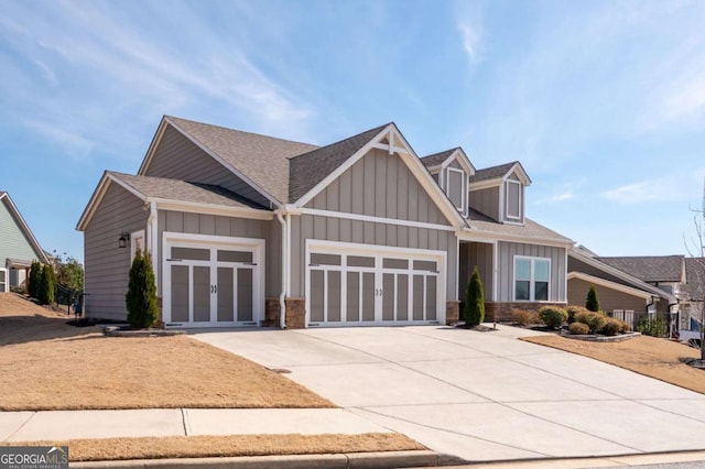 craftsman-style home featuring a garage, concrete driveway, roof with shingles, and board and batten siding