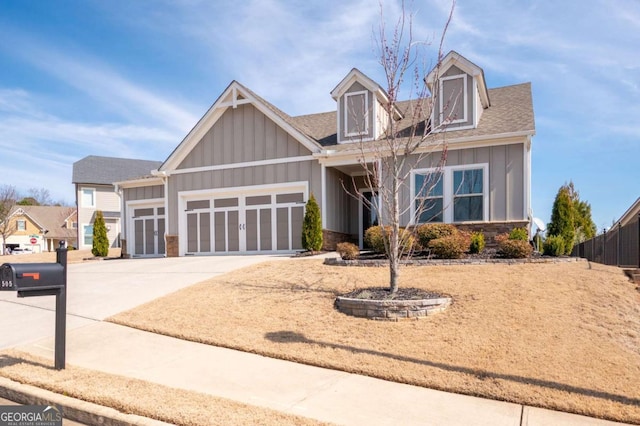 view of front of house with a garage, stone siding, board and batten siding, and concrete driveway