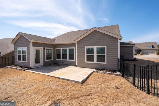 rear view of property with a patio area, a fenced backyard, a lawn, and roof with shingles