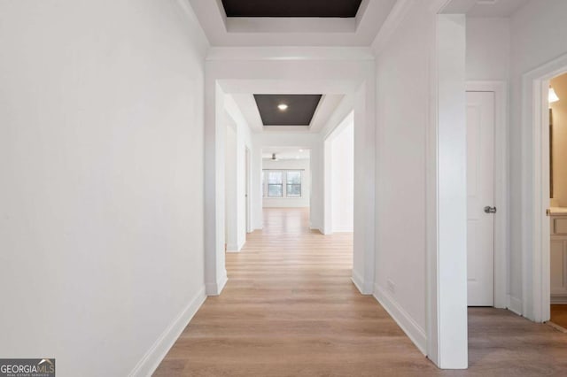 hall featuring light wood-style flooring and baseboards