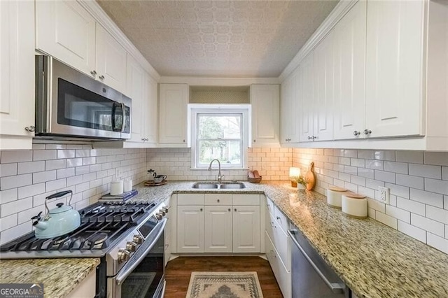 kitchen featuring white cabinetry, dark wood finished floors, appliances with stainless steel finishes, and a sink