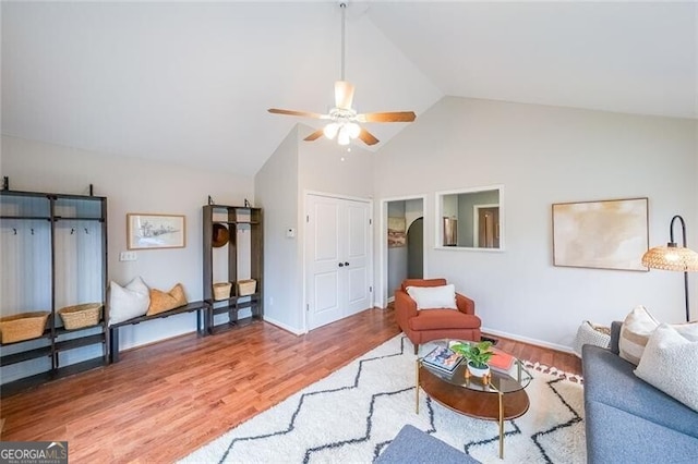 living area featuring high vaulted ceiling, wood finished floors, baseboards, and ceiling fan