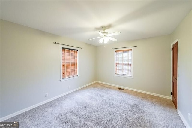 empty room featuring visible vents, baseboards, carpet, and a ceiling fan