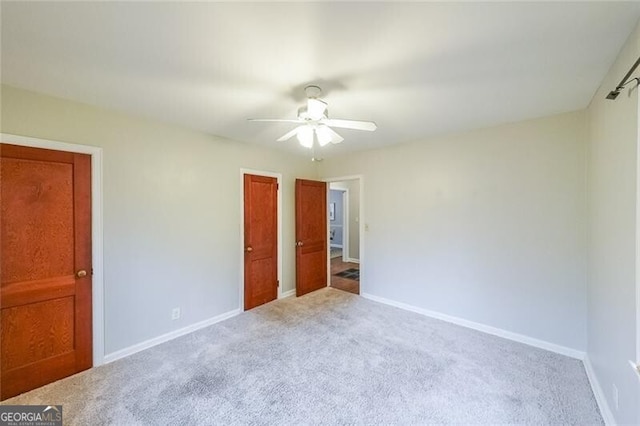 unfurnished bedroom with baseboards, carpet, and a ceiling fan