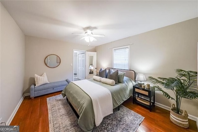 bedroom featuring a ceiling fan, baseboards, and wood finished floors