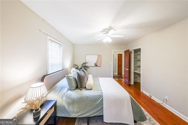 bedroom featuring ceiling fan, baseboards, and wood finished floors