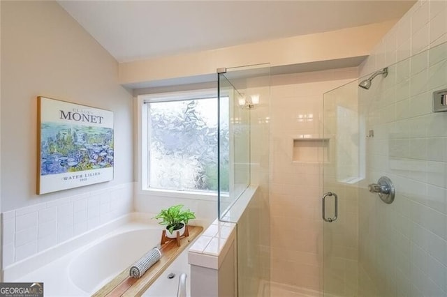 bathroom with a shower stall and a garden tub