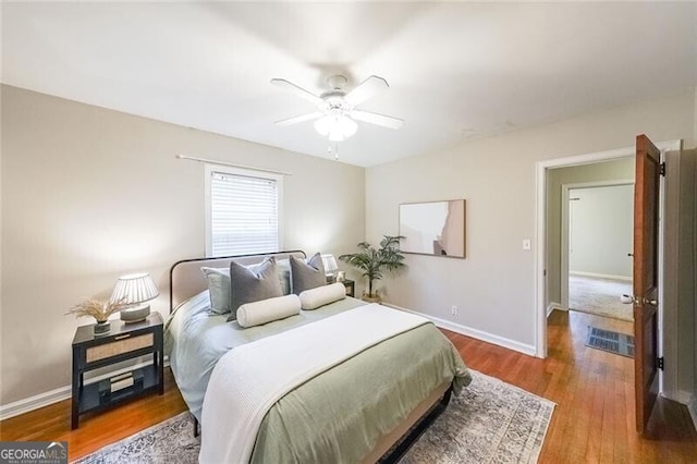 bedroom with wood finished floors, baseboards, and ceiling fan