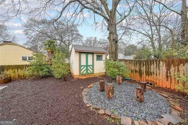 view of yard featuring a fenced backyard, a storage unit, and an outdoor structure