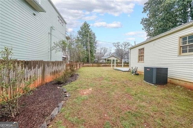 view of yard with central AC unit and fence private yard