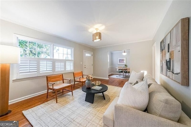 living area with baseboards and wood finished floors