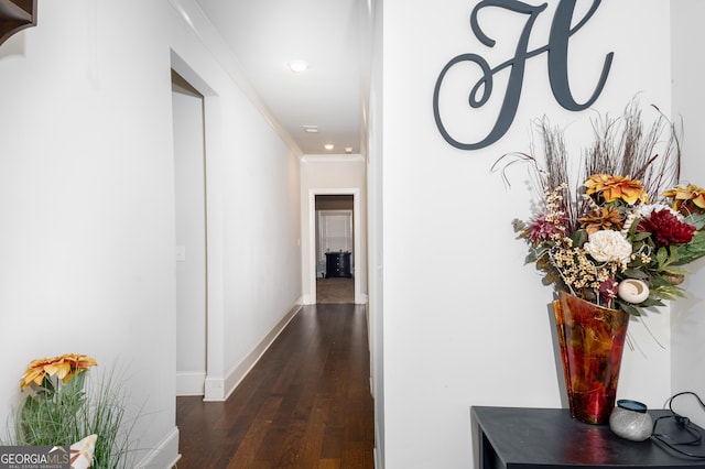 hallway with dark wood-type flooring, recessed lighting, ornamental molding, and baseboards