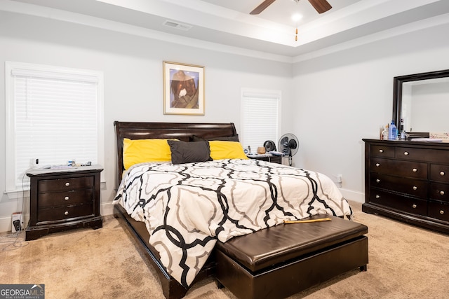 carpeted bedroom featuring a ceiling fan, a raised ceiling, visible vents, and baseboards