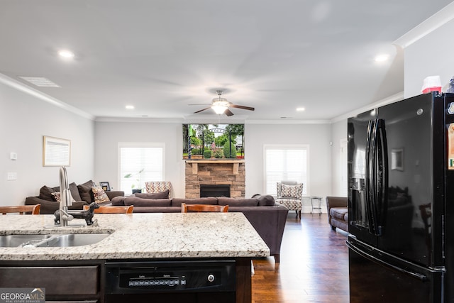 kitchen featuring ornamental molding, a sink, a fireplace, and black appliances