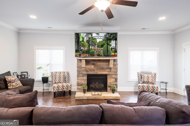 living area with a healthy amount of sunlight, crown molding, visible vents, and wood finished floors