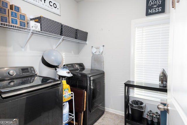 washroom with laundry area, baseboards, washer and clothes dryer, and tile patterned floors