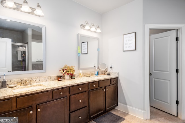 bathroom with double vanity, a stall shower, tile patterned flooring, and a sink