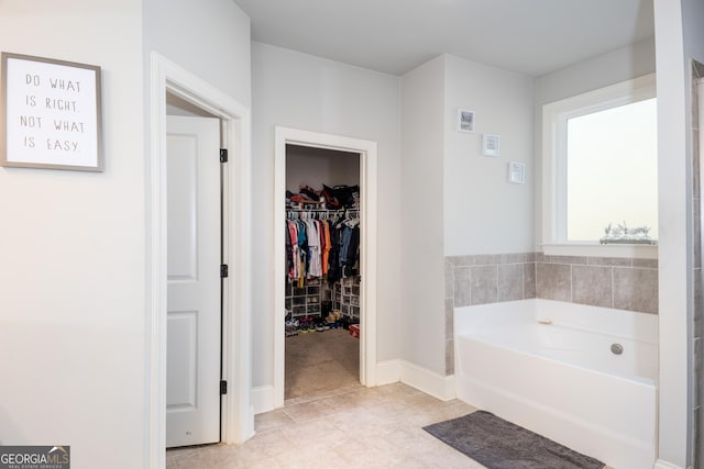 full bath with a spacious closet and a garden tub