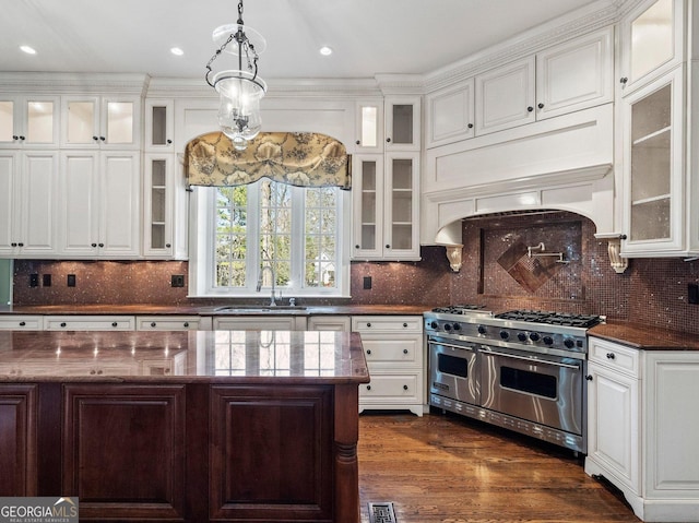 kitchen with white cabinets, double oven range, and a sink