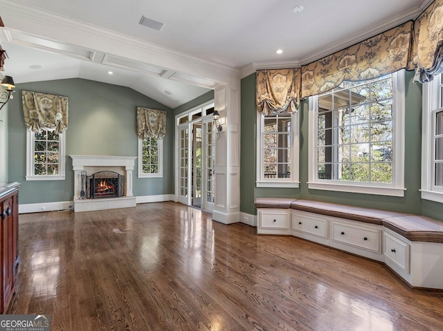 interior space with a wealth of natural light, wood finished floors, vaulted ceiling, and a premium fireplace