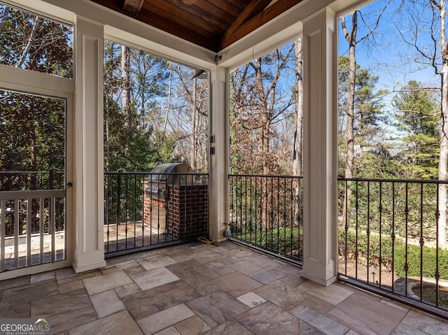 unfurnished sunroom featuring wood ceiling and vaulted ceiling