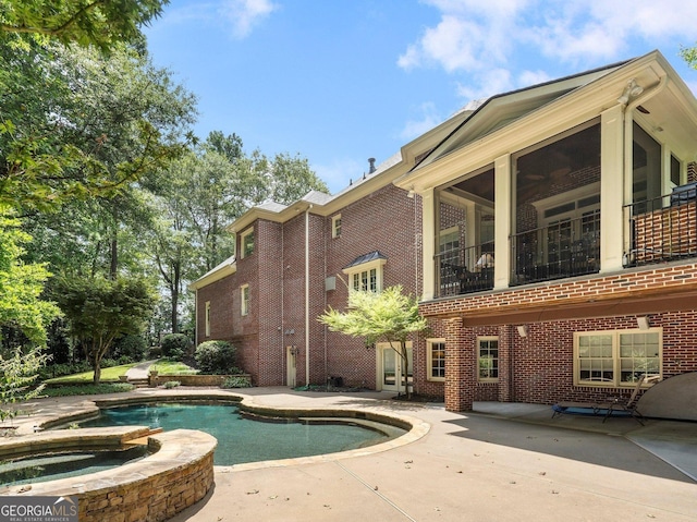 view of pool with a sunroom and a patio