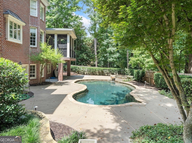 view of swimming pool with a pool with connected hot tub, a sunroom, a patio, and fence