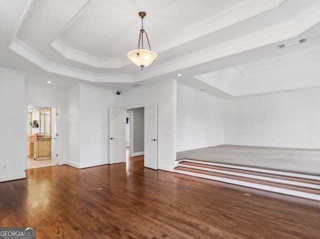 unfurnished bedroom with wood finished floors, a raised ceiling, visible vents, and crown molding