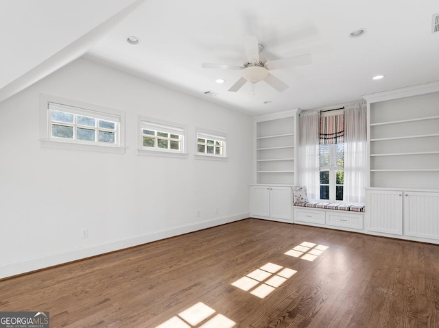 interior space with built in features, wood finished floors, visible vents, and baseboards