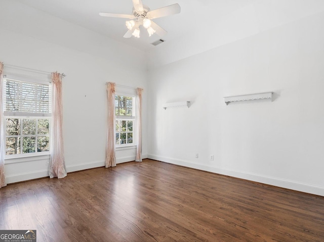 spare room featuring ceiling fan, wood finished floors, visible vents, and baseboards