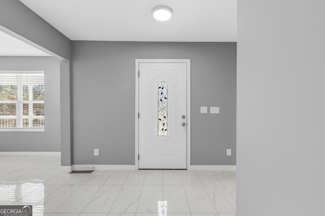 entrance foyer with marble finish floor and baseboards