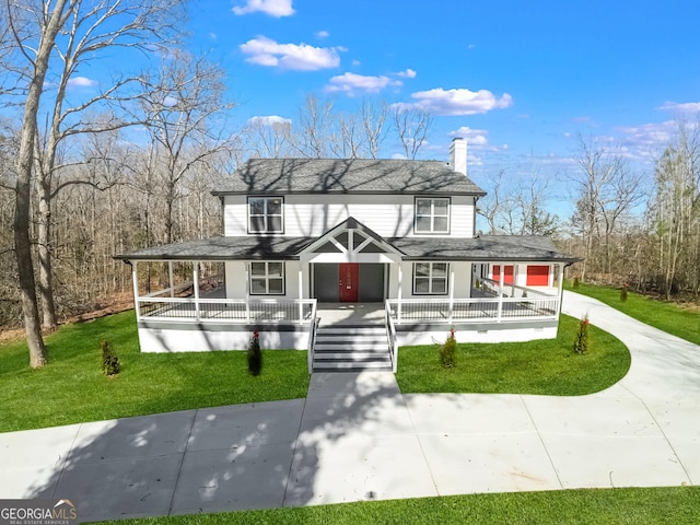 view of front of house featuring a porch, a shingled roof, driveway, a front lawn, and a chimney