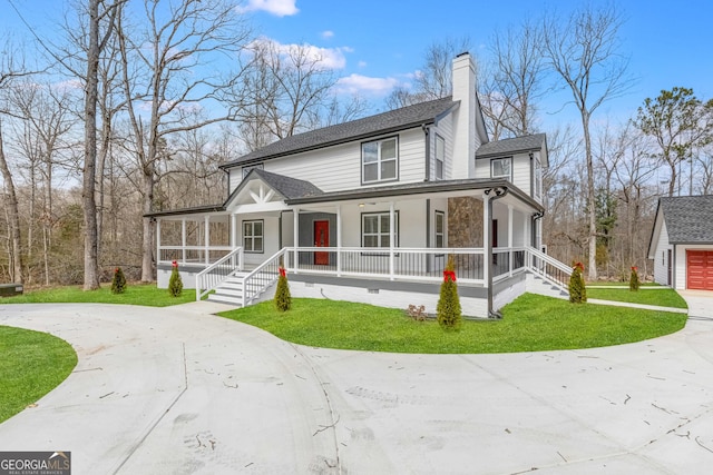 view of front of home featuring a porch, a front yard, driveway, and a chimney