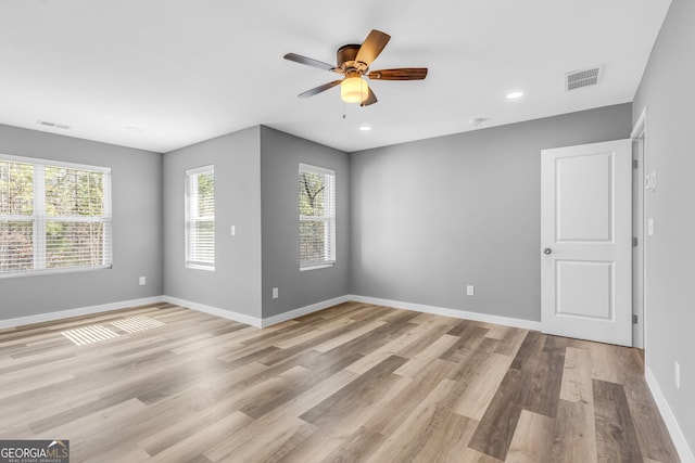 empty room with light wood finished floors, baseboards, visible vents, and recessed lighting