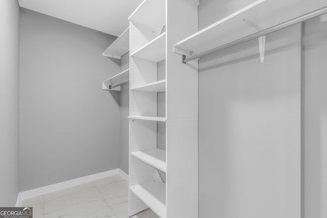 walk in closet with marble finish floor