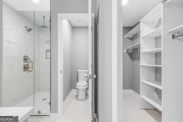 full bath featuring a marble finish shower, marble finish floor, baseboards, and toilet