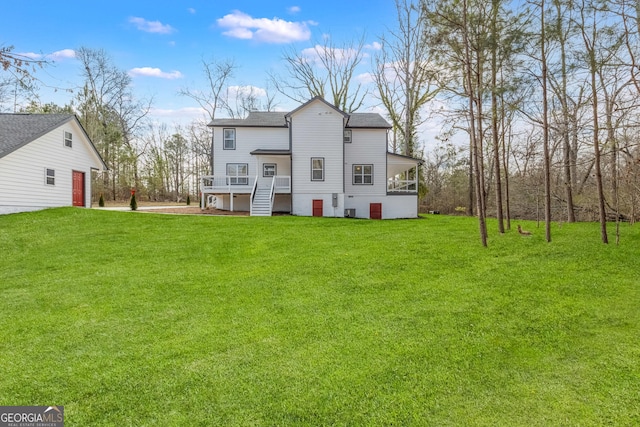 back of property with a yard and stairway