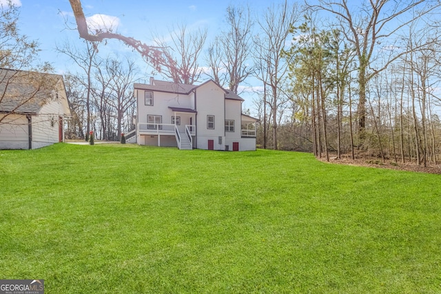 rear view of house featuring a chimney, stairway, and a lawn