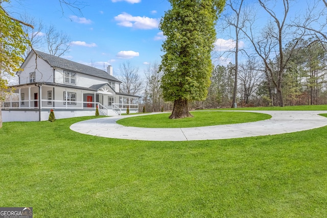 view of community featuring a lawn and driveway