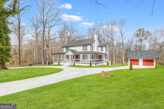 view of front of property with driveway, a front lawn, an outdoor structure, and a sunroom