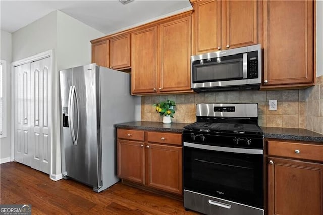 kitchen featuring appliances with stainless steel finishes, brown cabinets, and dark wood-type flooring