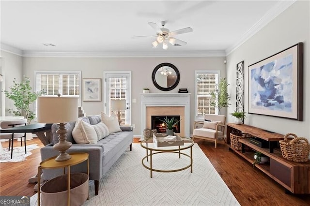 living room featuring ornamental molding, plenty of natural light, and wood finished floors