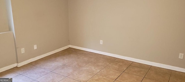 unfurnished room featuring light tile patterned flooring and baseboards