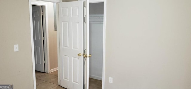 interior space featuring a closet, baseboards, and light tile patterned floors